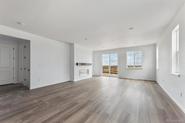 25283 E Warren Pl, Aurora, CO 80018 - unfurnished living room with wood finished floors, baseboards, and a glass covered fireplace