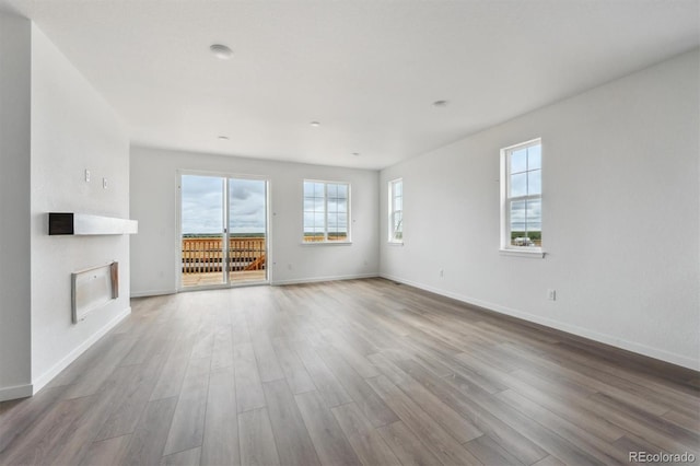25283 E Warren Pl, Aurora, CO 80018 - unfurnished living room featuring wood finished floors, baseboards, and a glass covered fireplace