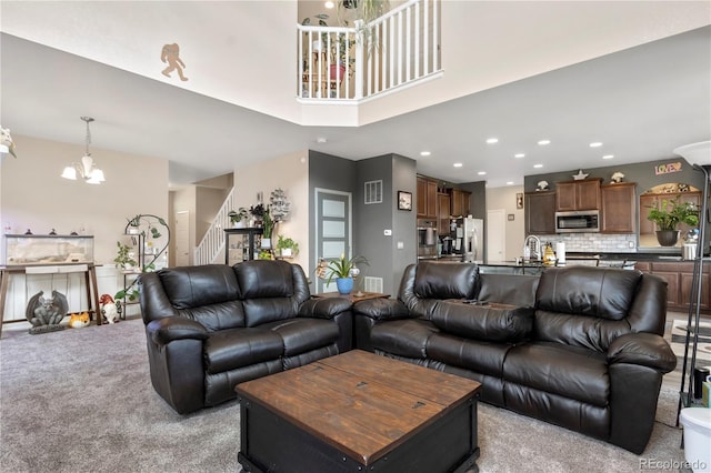 carpeted living room with an inviting chandelier and sink