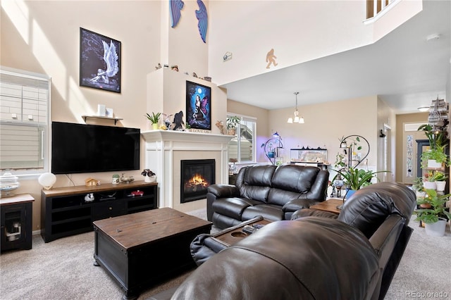 living room with a chandelier, a high ceiling, and carpet floors