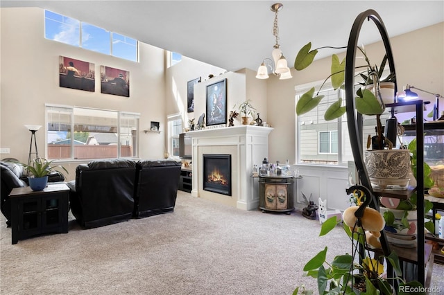 carpeted living room with a chandelier