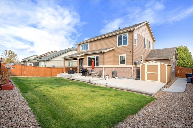 back of property featuring a lawn, a patio, and a storage unit