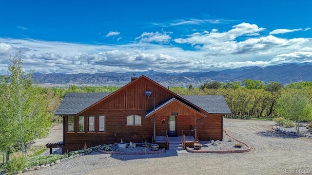 8126 Buck Run, Salida, CO 81201 - view of front of house with a chimney, a mountain view, a shingled roof, and driveway