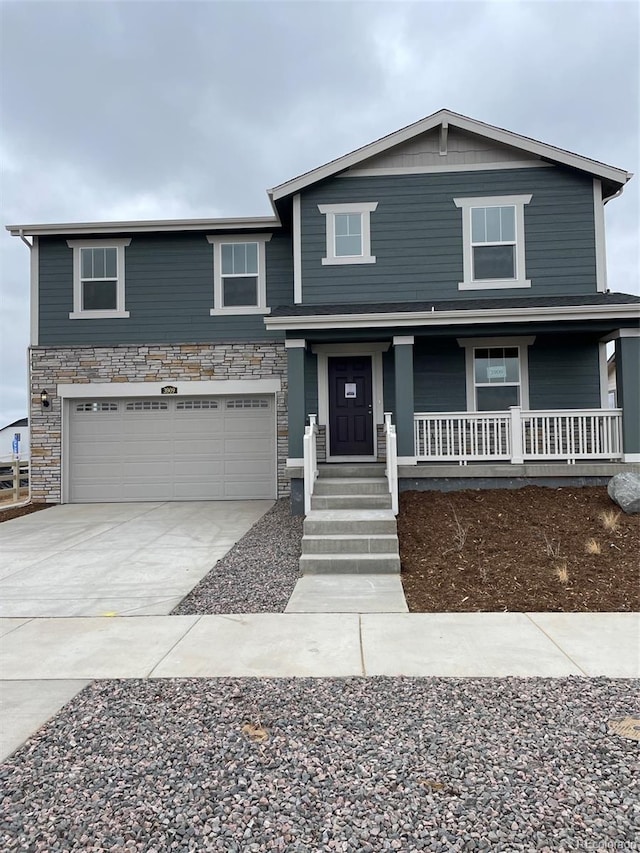 view of front of house with covered porch, driveway, stone siding, and an attached garage