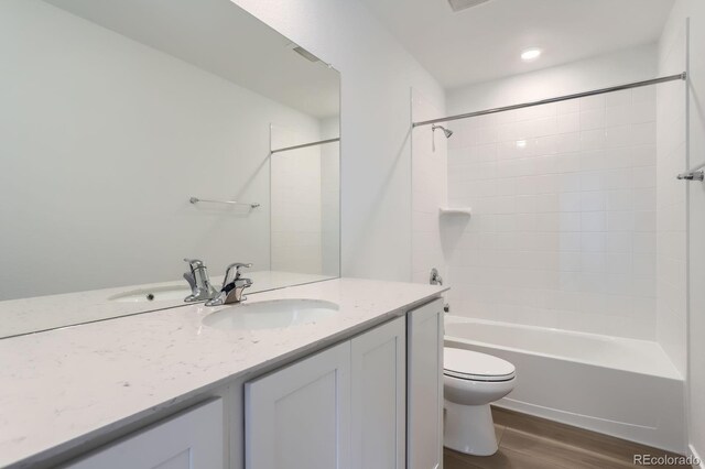 3909 N Shawnee St, Aurora, CO 80019 - full bathroom featuring visible vents, toilet, shower / washtub combination, wood finished floors, and vanity