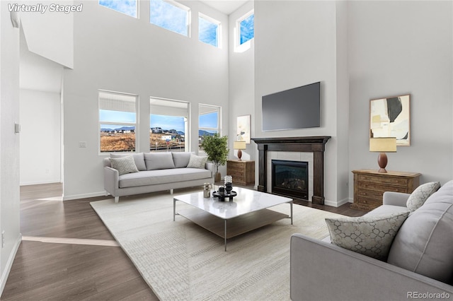 9359 Russell Cir, Arvada, CO 80007 - living area featuring a towering ceiling, baseboards, wood finished floors, and a fireplace