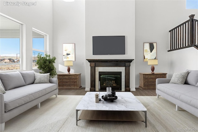 9359 Russell Cir, Arvada, CO 80007 - living room with a towering ceiling, wood finished floors, a tiled fireplace, and baseboards