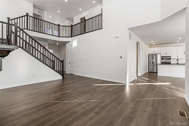 9359 Russell Cir, Arvada, CO 80007 - unfurnished living room featuring stairway, a sink, recessed lighting, dark wood finished floors, and baseboards
