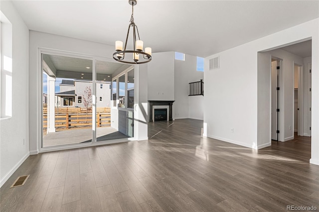 9359 Russell Cir, Arvada, CO 80007 - unfurnished dining area with a chandelier, dark wood-style floors, baseboards, and a fireplace