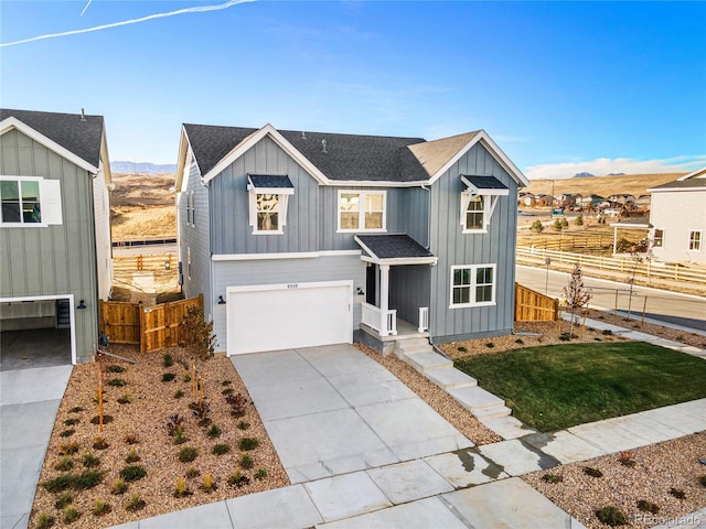 9359 Russell Cir, Arvada, CO 80007 - view of front of house featuring board and batten siding, an attached garage, a mountain view, driveway, and roof with shingles