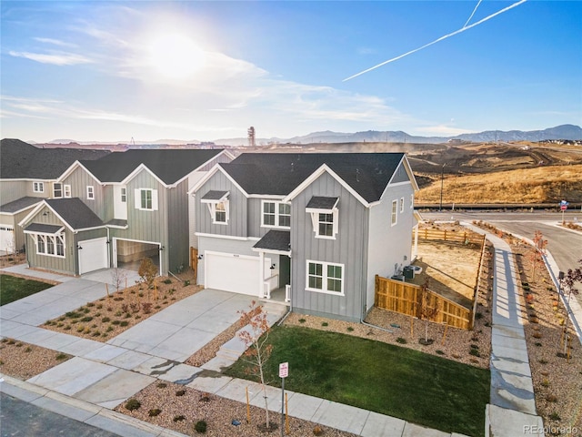 9359 Russell Cir, Arvada, CO 80007 - view of front of home with board and batten siding, an attached garage, driveway, and a mountain view