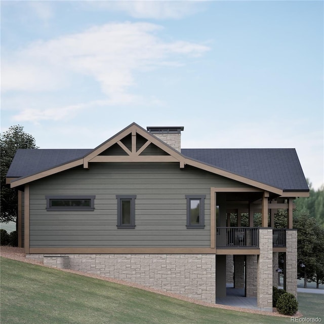 view of side of property featuring a balcony and a lawn