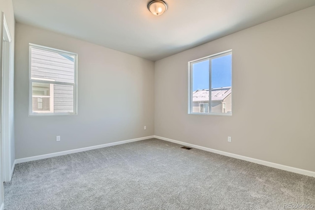 carpeted empty room with baseboards and visible vents