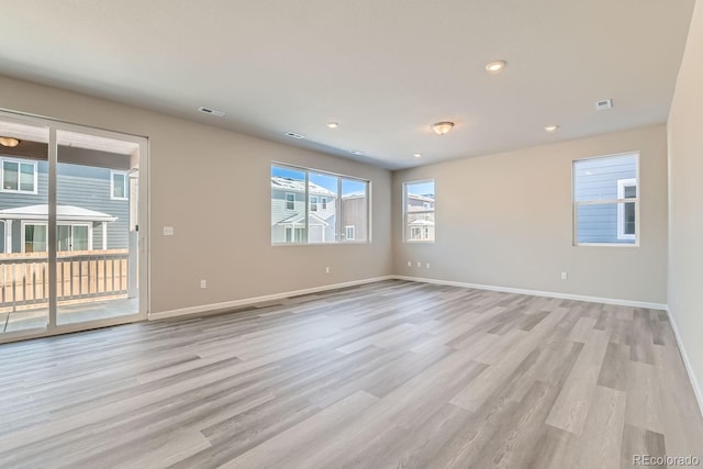 empty room with recessed lighting, visible vents, light wood-style flooring, and baseboards