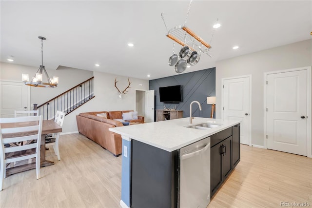 kitchen with a center island with sink, a notable chandelier, pendant lighting, sink, and stainless steel dishwasher