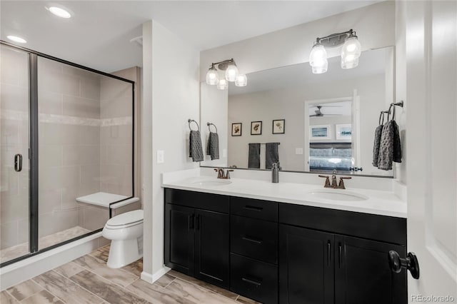 bathroom with toilet, ceiling fan, walk in shower, and vanity