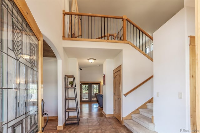 1715 Wales Dr, Berthoud, CO 80513 - tiled foyer with stairway, a high ceiling, arched walkways, and french doors
