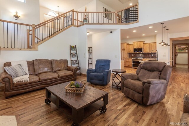 1715 Wales Dr, Berthoud, CO 80513 - living area featuring light wood finished floors, high vaulted ceiling, recessed lighting, and stairway