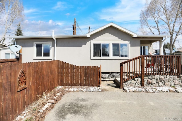view of front of home featuring stucco siding and fence