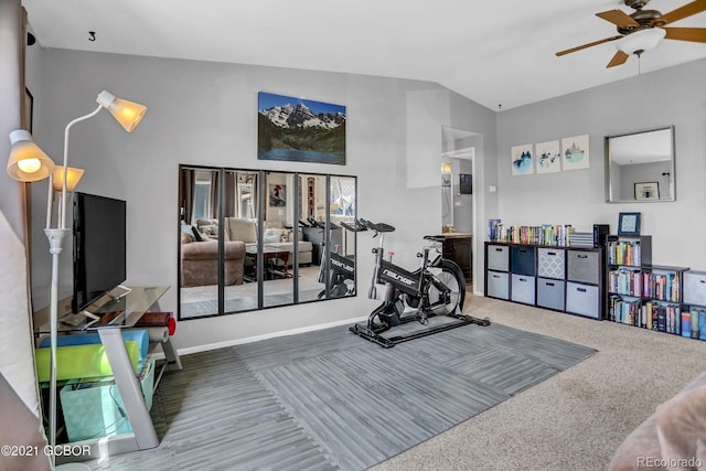 workout area featuring baseboards, ceiling fan, and vaulted ceiling