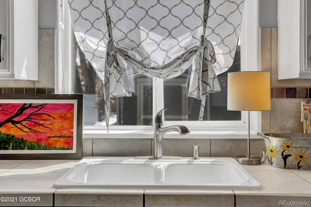 room details featuring white cabinetry, light countertops, and a sink