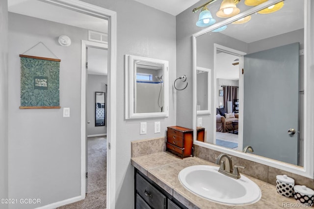 bathroom featuring visible vents, vanity, ensuite bathroom, and baseboards