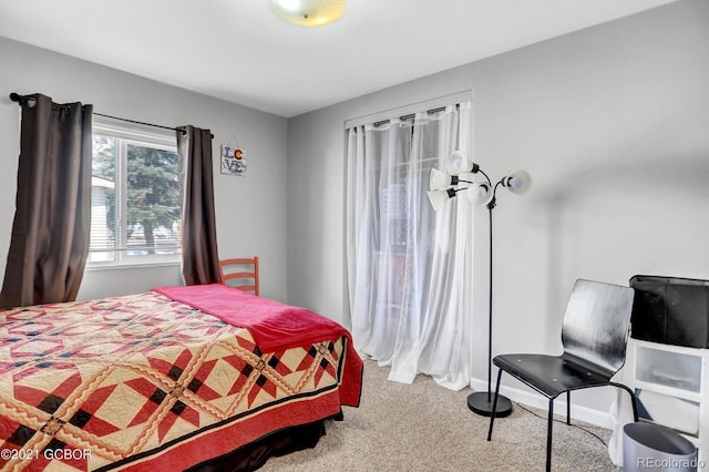 bedroom with light colored carpet and baseboards