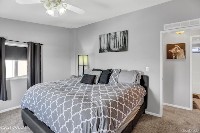 carpeted bedroom featuring baseboards, visible vents, and ceiling fan