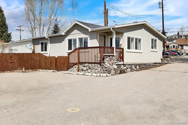 view of front of home with stucco siding and fence