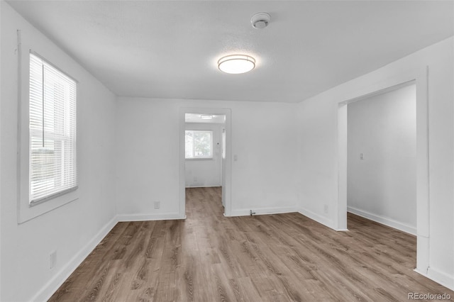 empty room featuring a healthy amount of sunlight and light hardwood / wood-style flooring