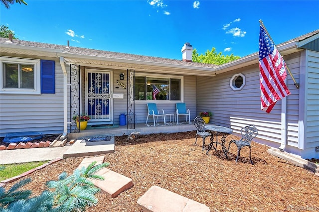 3313 S Dexter St, Denver, CO 80222 - property entrance featuring covered porch and a chimney