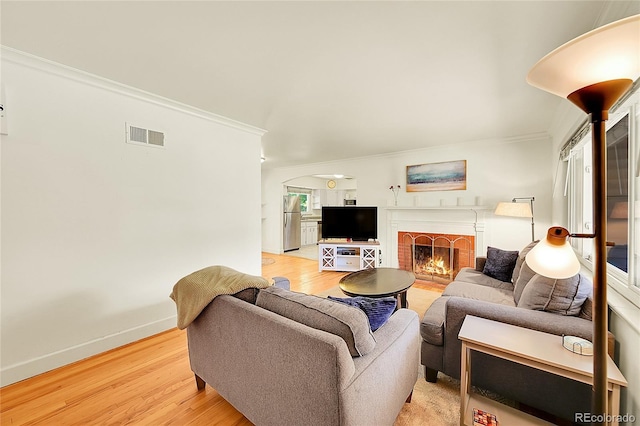 3313 S Dexter St, Denver, CO 80222 - living room with ornamental molding, light wood-type flooring, arched walkways, and a fireplace