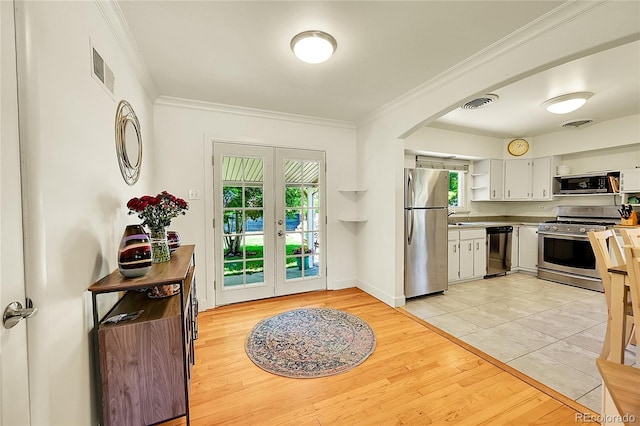 3313 S Dexter St, Denver, CO 80222 - kitchen featuring appliances with stainless steel finishes, french doors, open shelves, arched walkways, and white cabinetry