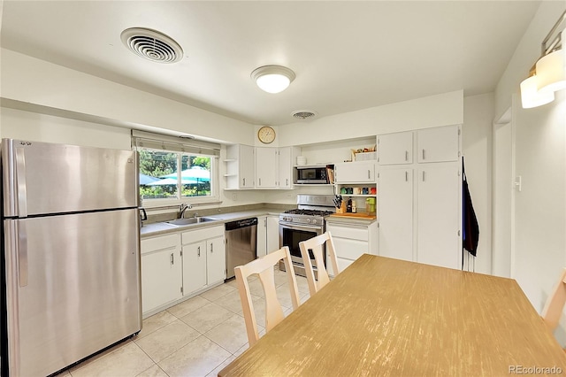 3313 S Dexter St, Denver, CO 80222 - kitchen with appliances with stainless steel finishes, open shelves, light tile patterned floors, and white cabinets