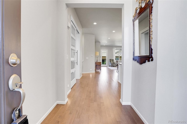 hall featuring built in shelves and light hardwood / wood-style floors