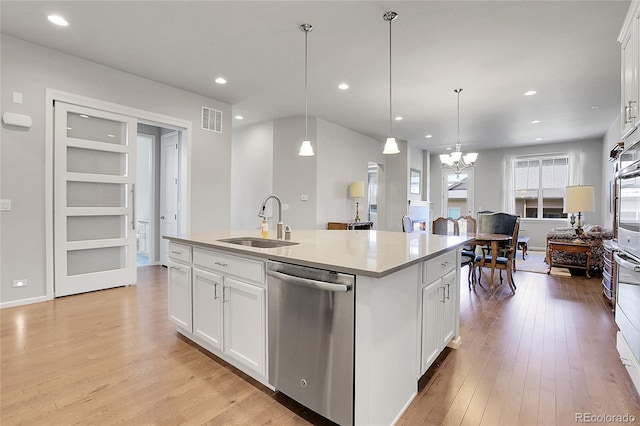 kitchen featuring an island with sink, white cabinetry, sink, and dishwasher