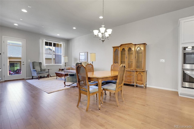 dining space with light wood-type flooring and a chandelier