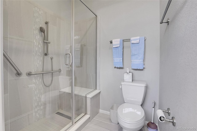 bathroom with toilet and a shower with door