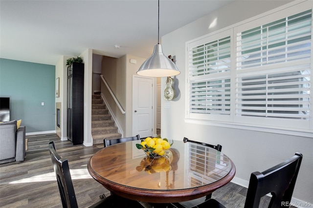 dining area featuring stairs, baseboards, and wood finished floors