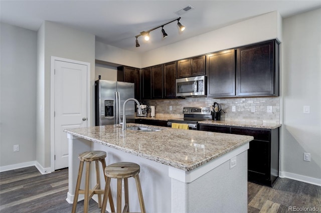 kitchen with backsplash, visible vents, stainless steel appliances, and a sink