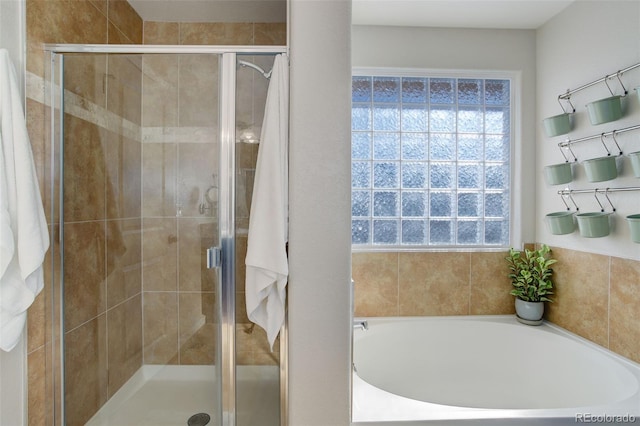 bathroom with a garden tub and a shower stall