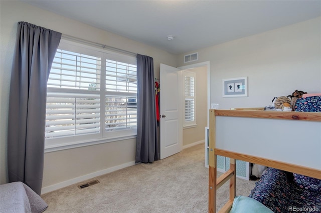 carpeted bedroom featuring visible vents and baseboards