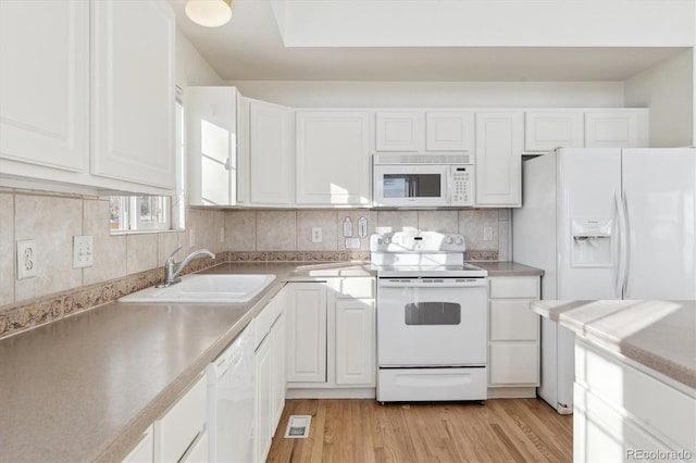 kitchen with sink, white cabinetry, light hardwood / wood-style flooring, white appliances, and decorative backsplash