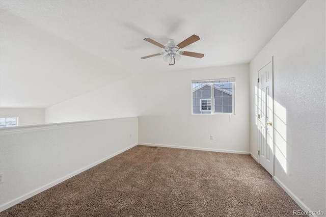 carpeted spare room with lofted ceiling, a healthy amount of sunlight, and ceiling fan