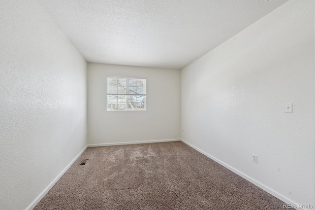 carpeted empty room with a textured ceiling