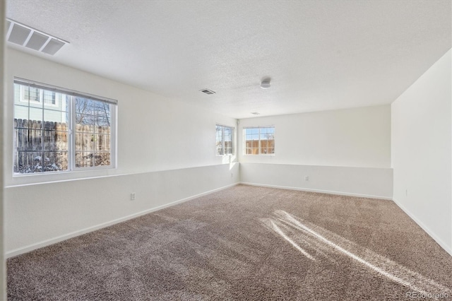 carpeted spare room featuring a textured ceiling