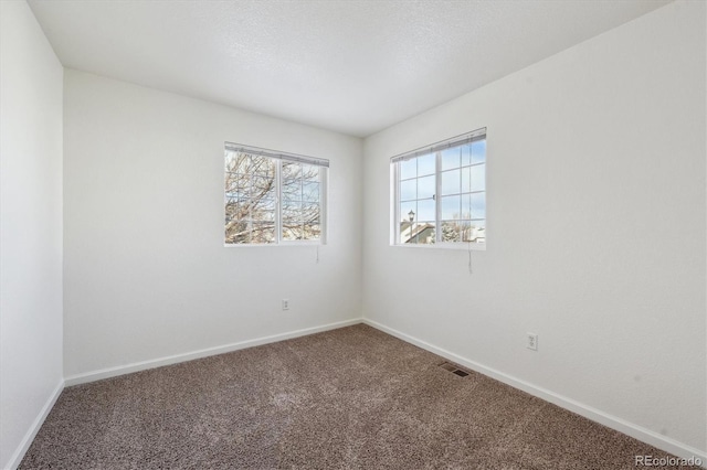 unfurnished room featuring carpet floors and a textured ceiling