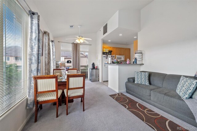 living room with visible vents, ceiling fan, light colored carpet, and lofted ceiling