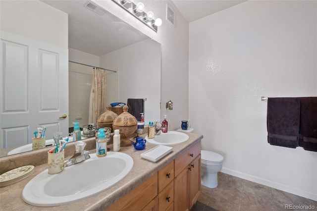 bathroom with double vanity, visible vents, toilet, and a sink