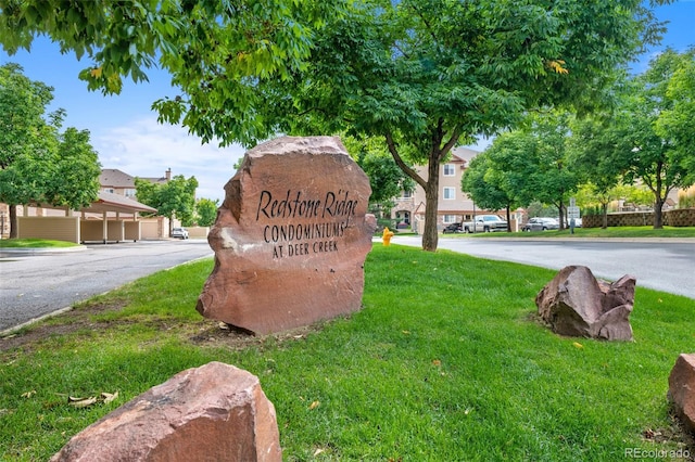 community / neighborhood sign featuring a yard